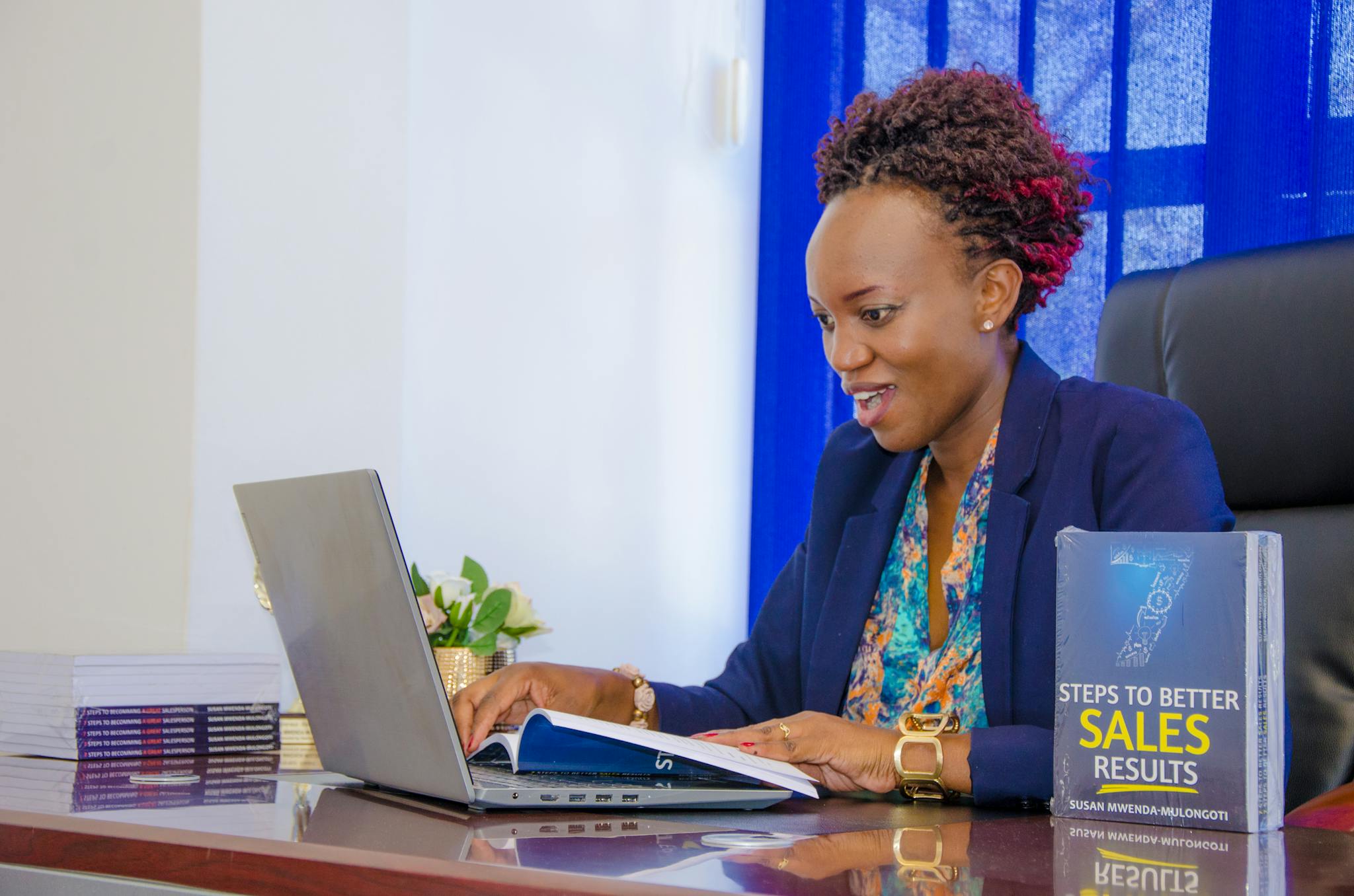 Businesswoman in office setting actively working on a laptop, showcasing productivity and focus.